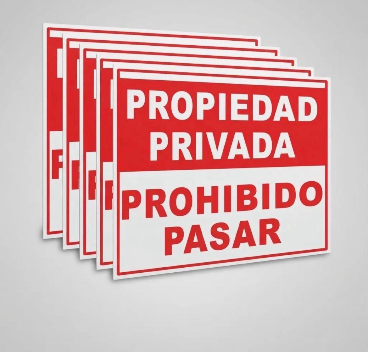 Pila de carteles rojos y blancos con la leyenda propiedad privada, prohibido pasar